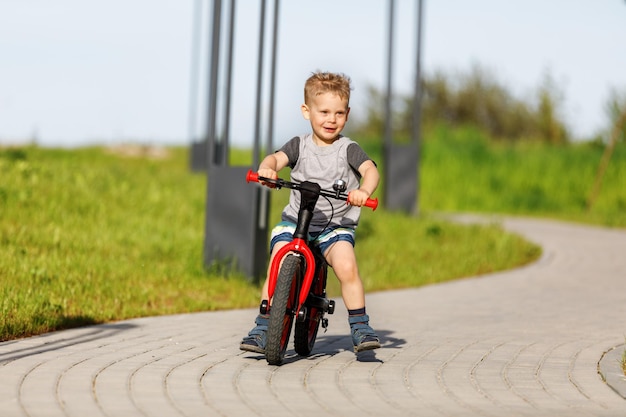 Little boy riding a bike in a city park