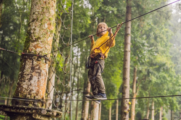 Little boy in a rope park Active physical recreation of the child in the fresh air in the park Training for children