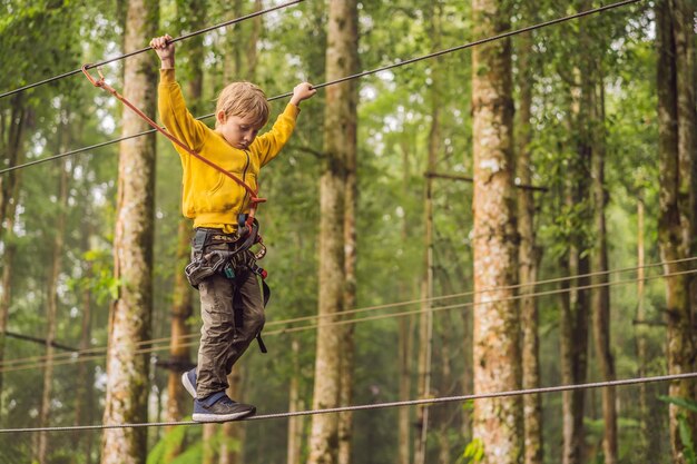 Маленький мальчик в веревочном парке Активный физкультурный отдых ребенка на свежем воздухе в парке Тренировки для детей