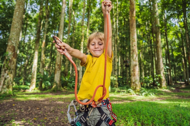 Little boy in a rope park Active physical recreation of the child in the fresh air in the park Training for children