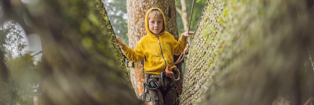 Маленький мальчик в веревочном парке активный физический отдых ребенка на свежем воздухе в парке