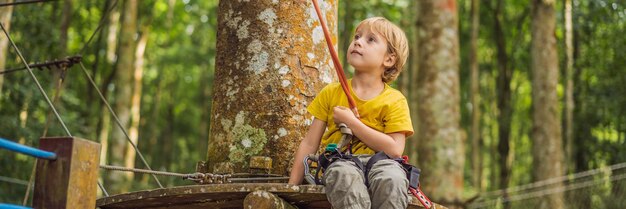 Маленький мальчик в веревочном парке активный физический отдых ребенка на свежем воздухе в парке