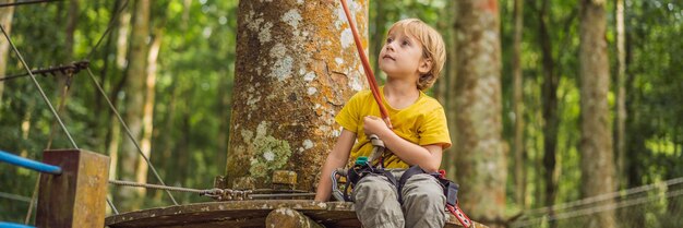 Little boy in a rope park active physical recreation of the child in the fresh air in the park