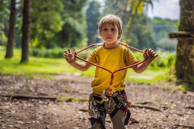 Little boy in a rope park active physical recreation of the child in the fresh air in the park