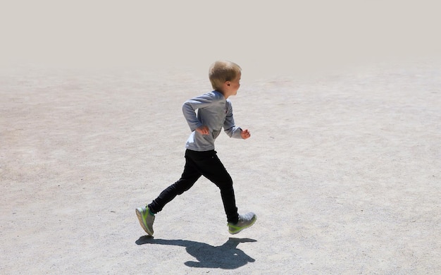 Little boy running isolated on the grey background