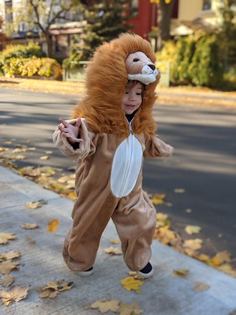 Photo little boy running in lion costume