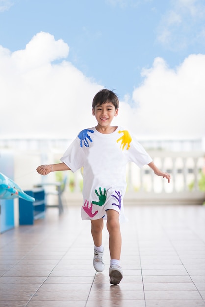 Little boy running at school with happy face