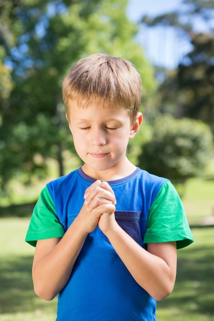 彼の祈りを言っている小さな男の子