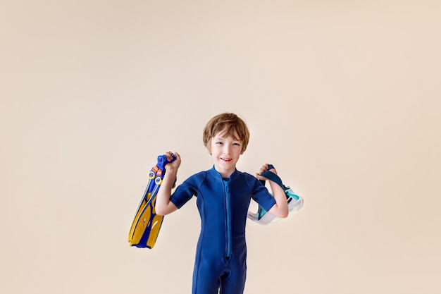 Little boy in scuba mask and snorkel on sand background.