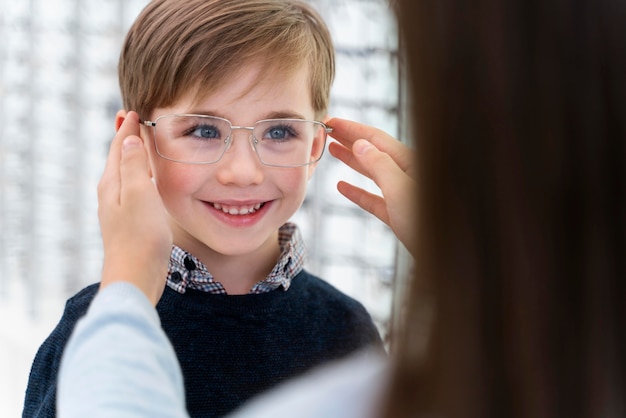 Little boy and sister in store trying on glasses