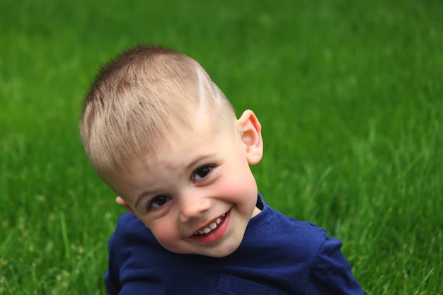 Little boy sits on the grass. Selective focus