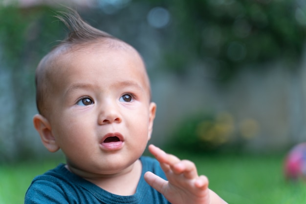 庭に座っている小さな男の子