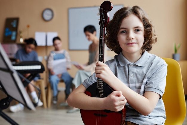 Foto ragazzino seduto in classe di musica