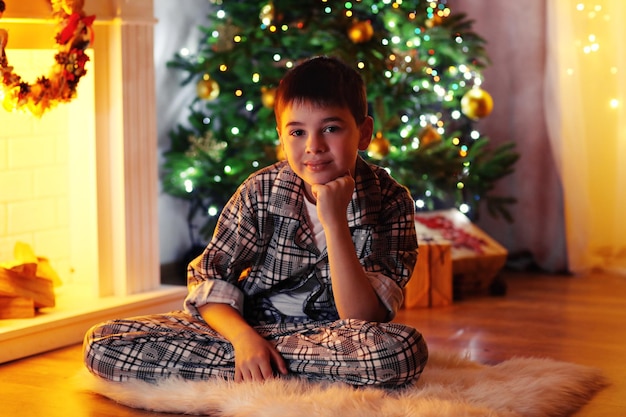 Little boy sitting near fireplace in room