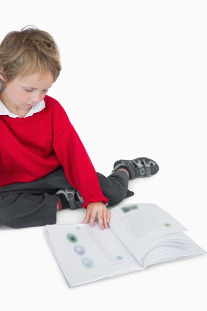 Little boy sitting and reading book