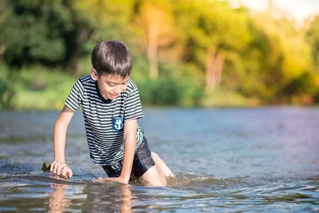 Little boy sitting together at the river canal