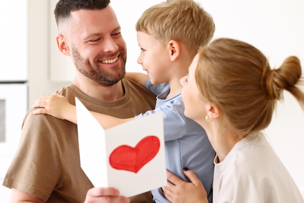 little boy son congratulating daddy with fathers day at home