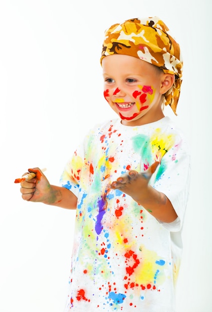 Little boy stained in paint draws