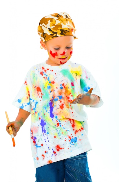 Little boy stained in paint draws