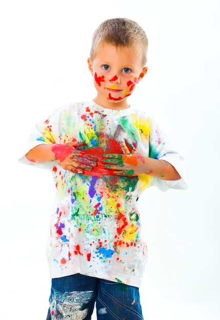 Little boy stained in paint draws