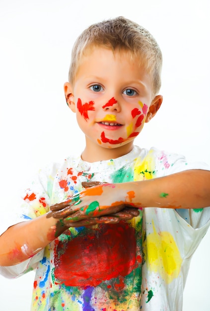 Little boy stained in paint draws