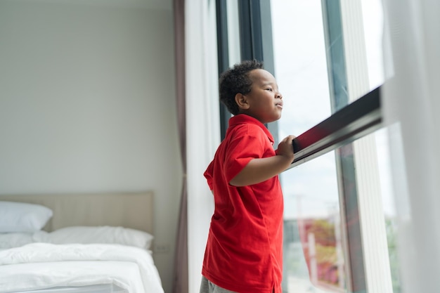 Il bambino stava guardando fuori dalla finestra in una giornata limpida