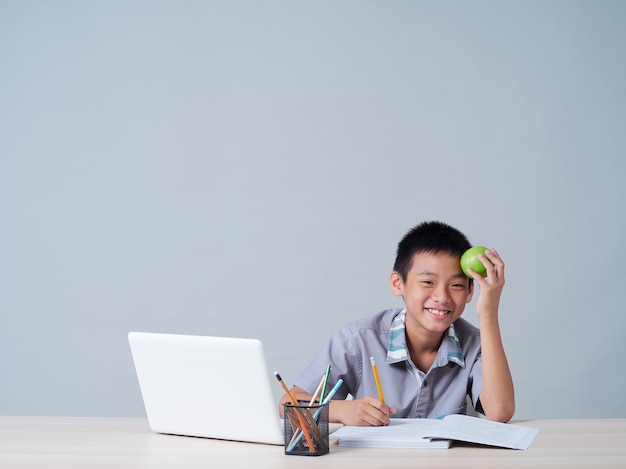 Ragazzino che studia in linea con il computer portatile. apprendimento a distanza durante la pandemia covid-19