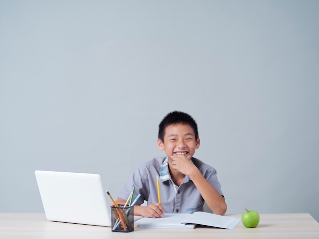 Ragazzino che studia in linea con il computer portatile. apprendimento a distanza durante la pandemia covid-19