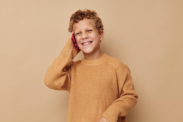 Foto ragazzino in un maglione che parla al telefono