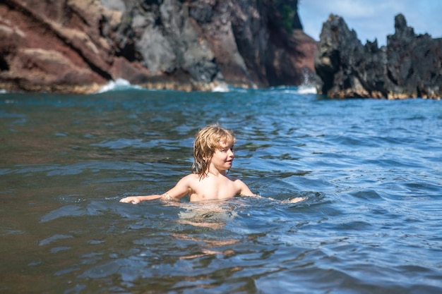 Little boy swimming in the sea kid on a tropical beach summer kids vacation