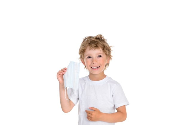 Photo little boy takes off the protective medical mask from his face and smiles