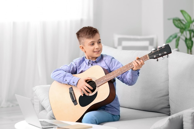 Little boy taking music lessons online at home