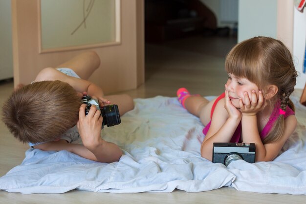 Little boy taking a picture of a little girl