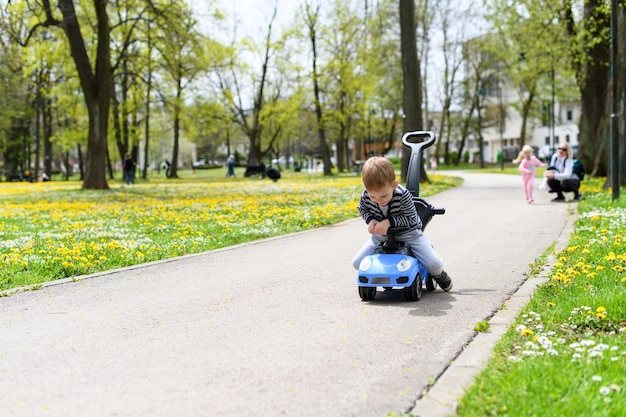 おもちゃの車を運転することを教える小さな男の子