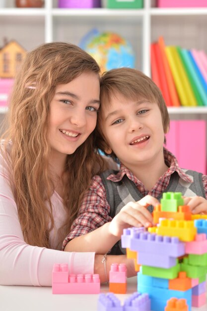 Little boy and teenage girl playing lego game togehter