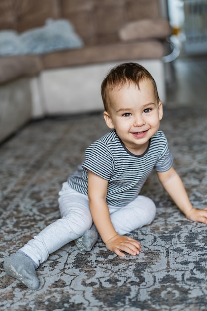 A little boy that is sitting on the floor