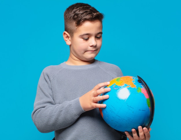 Little boy thinking expression and holding a world map model