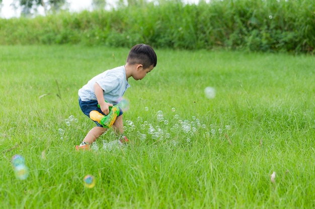 Little boy touching bubble on ground