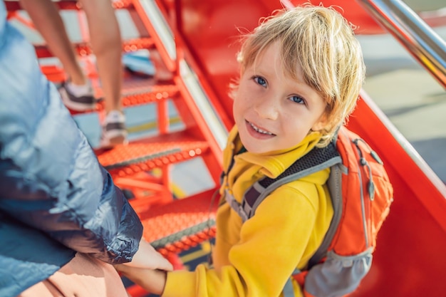 飛行機に搭乗する小さな男の子の旅行者