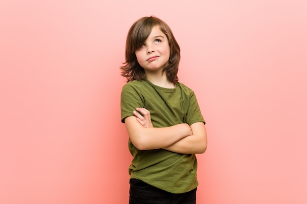 Little boy unhappy looking in camera with sarcastic expression.