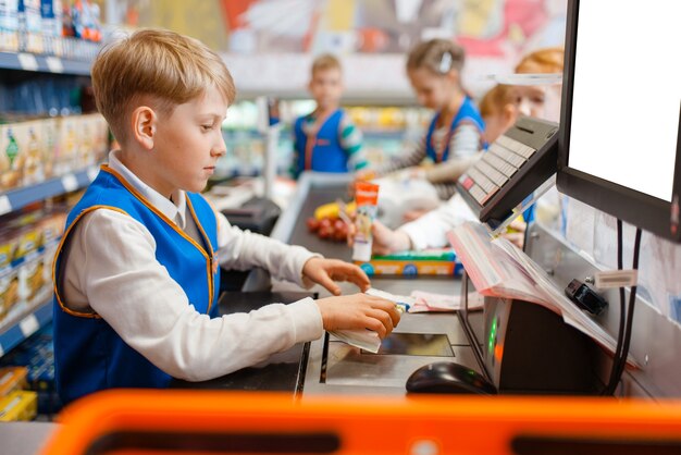 Little boy in uniform at the register playing salesman