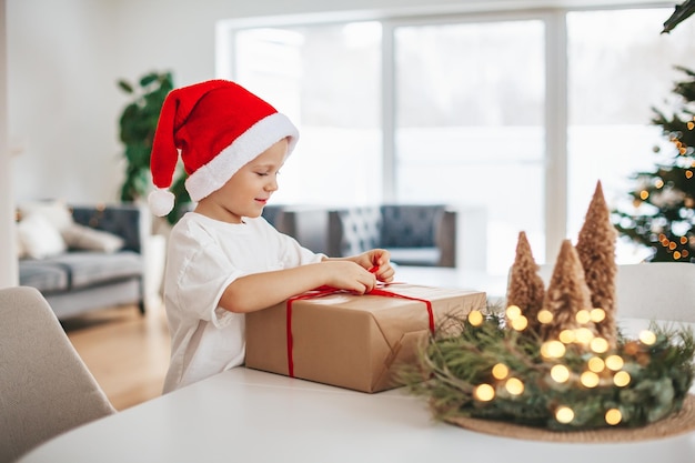 Little boy untying a bow on a gift box