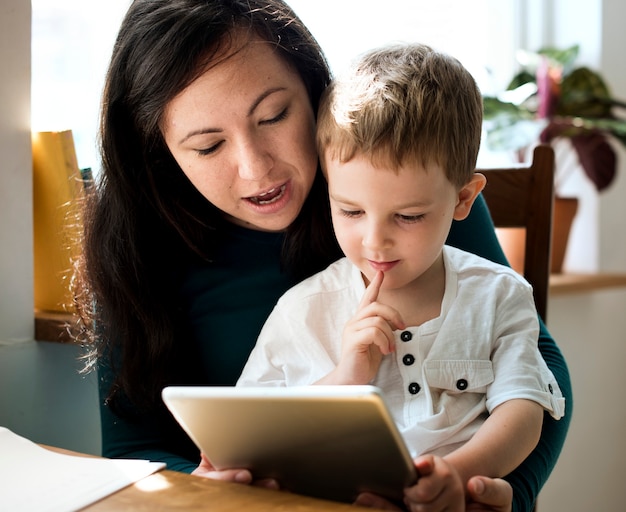 Little boy using a tablet with his mom