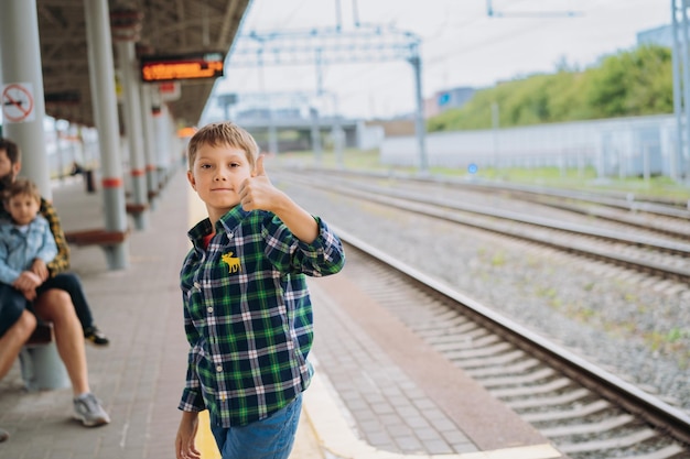 Little boy waiting for train Father and son waiting at platform