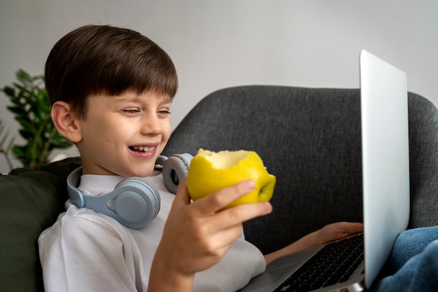 Photo little boy watching films on the laptop