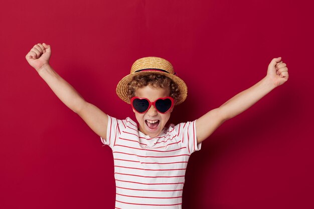 Little boy wearing sunglasses and hat posing fashion childrens style