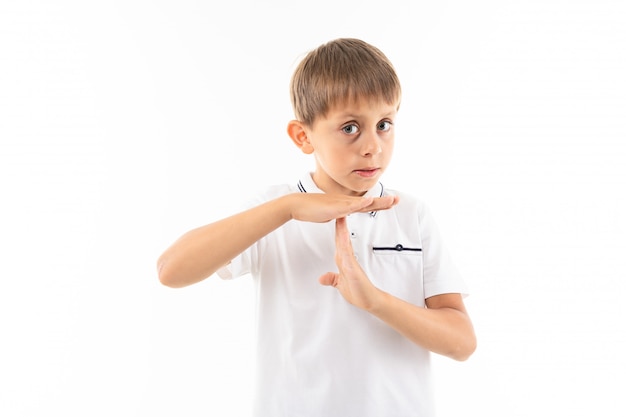 A little boy in a white shirt, blue shorts with blonde hair, white t-shirt shows "timeout"