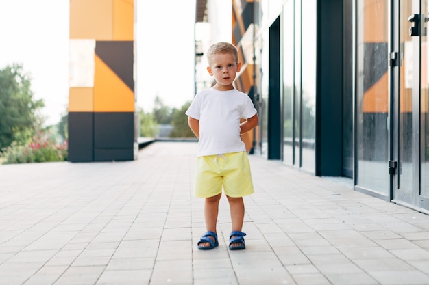 白いTシャツを着た小さな男の子。ロゴやデザインのためのスペース。印刷用のモックアップ