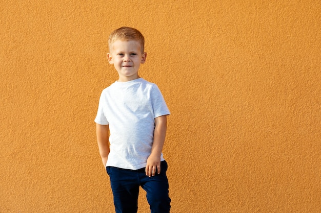 Маленький мальчик в белой футболке. место для вашего логотипа или дизайна. Мокап для печати