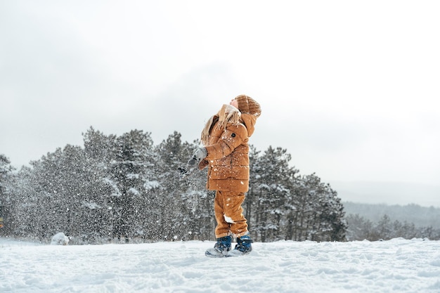 Ragazzino in un parco o in una foresta d'inverno